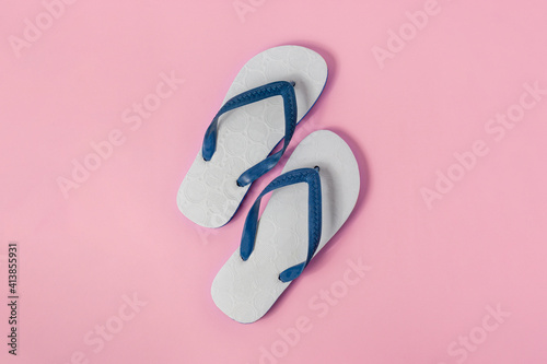 A pairs of white sandals on light pink background.