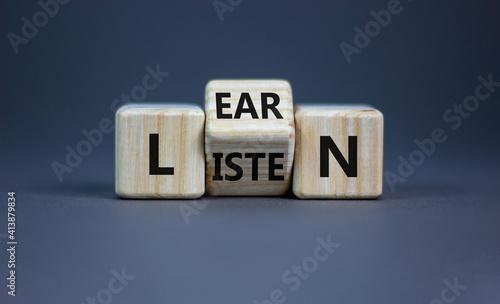 Listen and learn symbol. Turned a wooden cube and changed the word 'listen' to 'learn'. Beautiful grey background, copy space. Business, education and listen and learn concept.