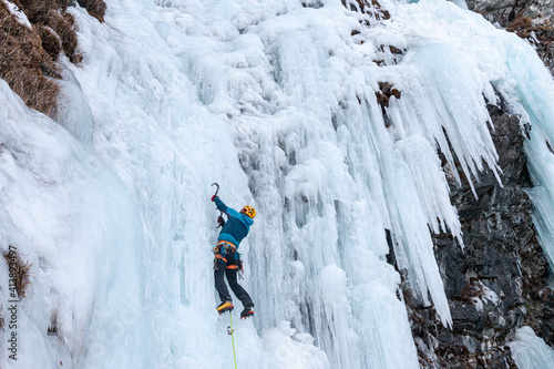 Ice climber on frozen waterfall, Cogne, Aosta Valley, Italy