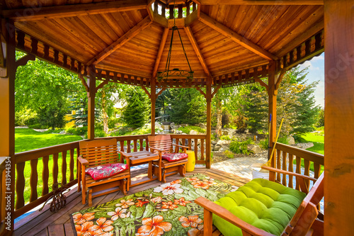 View of a wooden gazebo in the landscaped garden of an upscale home.