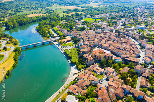 View from drone of cityscape of small French town of Cazeres on river Garonne in summer