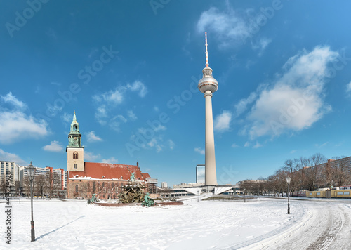 Berlin under snow. Alexanderplatz with famous TV tower. Berlin under snow. Panoramic image with television tower, Neptun fountain and Marienkirche, old church.
