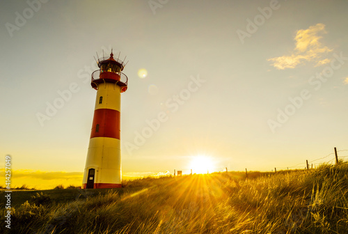 Sunset at the lighthouse List East on a dune of the island Sylt, North Sea, Germany 