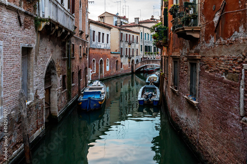 Venice's canal, boat and traditional Venetian houses view. 