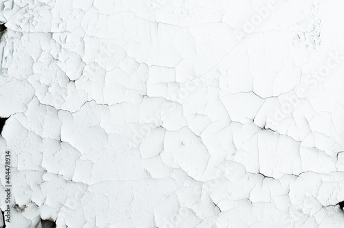Old faded background, cracked white paint on the wall, surface with cracks