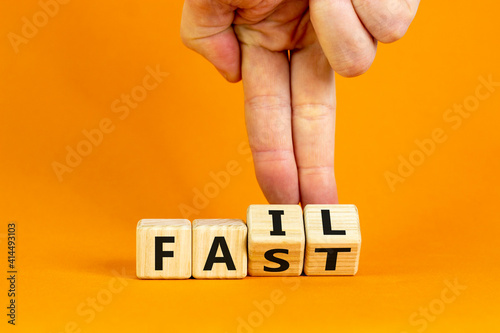 Fail fast symbol. Businessman turns wooden cubes with words 'fail fast' on beautiful orange background, copy space. Business and fail fast concept.