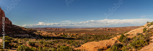 Panorama shot of road in shadow of sandstone mountain in american desert in arches national park in utah, america