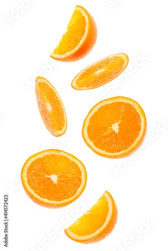 falling fresh orange fruit slices isolated on white background closeup. Flying food concept.