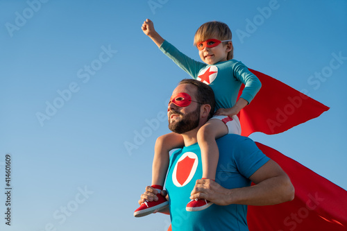 Father and son playing against blue summer sky background