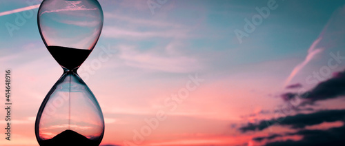 Time passing at sunset with hourglass