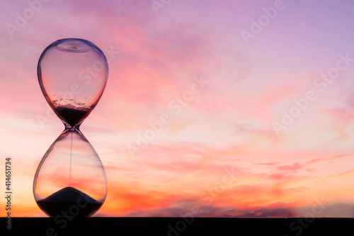 Time passing at sunset with hourglass