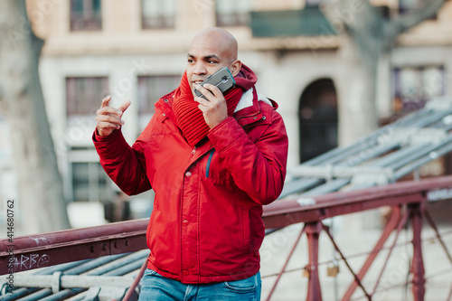 young latin man with smartphone in the city of lyon