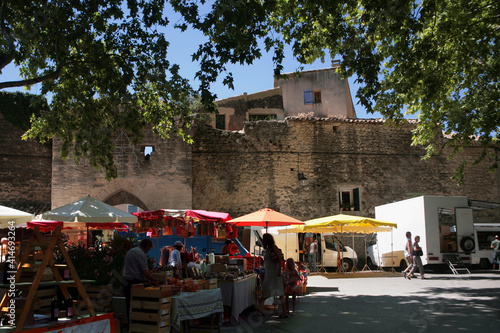Cucuron, Vaucluse, Provence-Alpes-Cote d'Azur, France: market stalls and coloured sunshades by the old fortifications