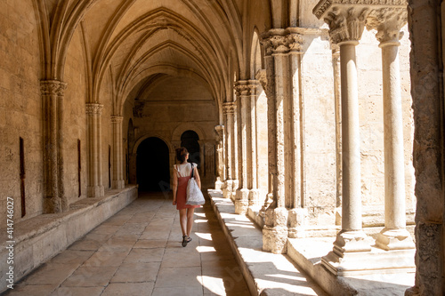 Tourist woman visiting the cloister of the cathedral of Arles, France,