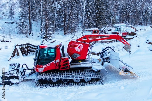 Red ratrak on the background of a snow-covered forest