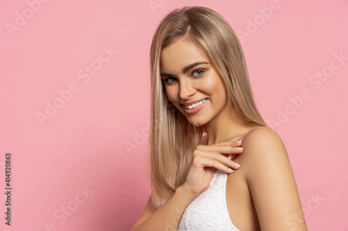 Portrait of beautiful blonde woman with long straight hair over pastel background