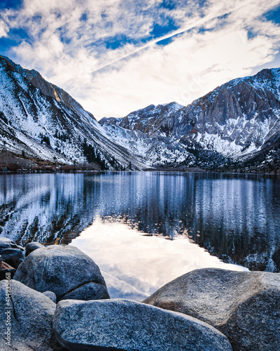 Mesmerizing view of the lake and snowy mountains against cloudy sky in Mammoth Lakes, California