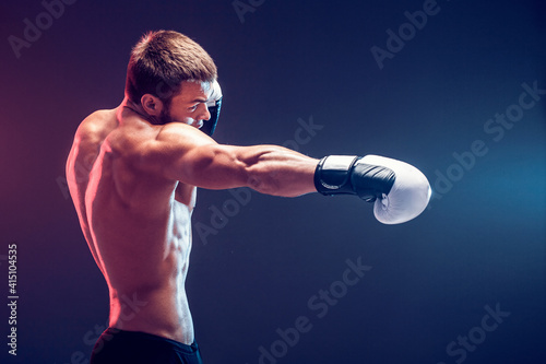 shirtless boxer with gloves on dark background. Isolate