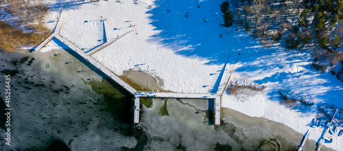Zimowy widok z lotu ptaka na główną plażę nad skutym lodem jeziorem Głębokie, lubuskie, Polska 