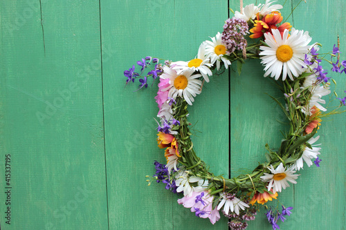 Flower door wreath. Midsummer flower crown on rustic wooden background with copy space. DIY floral wreath. Midsummer night dream decoration 