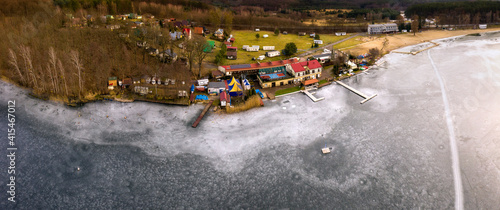 Zimowy krajobraz w miejscowości Długie, widok z lotu ptaka na jezioro skute lodem i brzeg głównej plaży jeziora Lipie, lubuskie