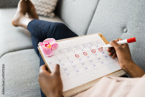 African Woman Using Menstrual Cycle Calendar