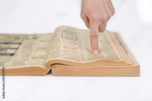 Finger pointing out in a phonebook on a white