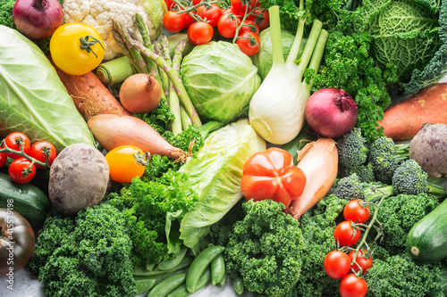 Abundance of different vegetables broccoli cauliflower cabbage kale pak choy onions tomatoes. Healthy local produce on white wooden table, top view, selective focus