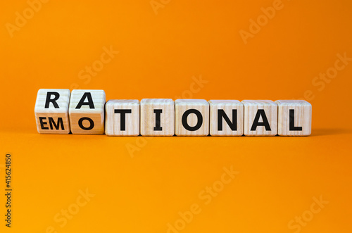 Rational or emotional symbol. Turned wooden cubes and changed the word 'rational' to 'emotional'. Beautiful orange background. Psychological and rational or emotional concept. Copy space.