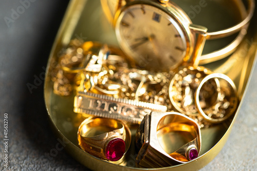 Old and broken jewelry, vintage watches on dark background. Sell gold for cash concept.