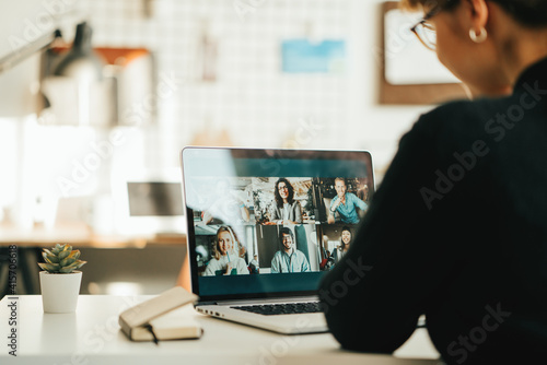 Woman has video call with her team using laptop and camera