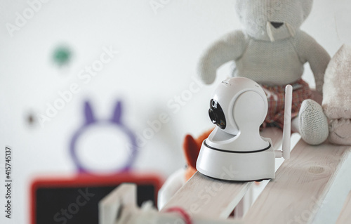 IP camera on the shelf with toys, serving as baby monitor