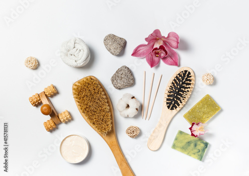Eco-friendly wooden accessories for massage, peeling and spa treatments on a light wooden background