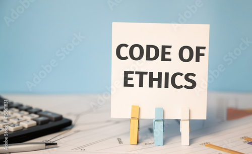 CODE OF ETHICS on a sticker beside a calculator and a pen. Finances and business concept.