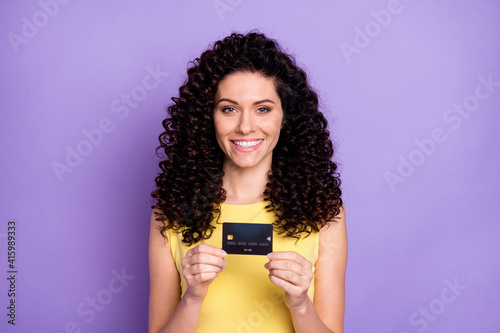 Photo of charming positive person hands hold banking card toothy smile isolated on violet color background
