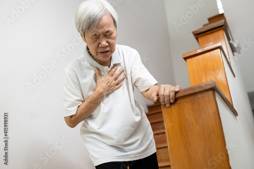 Asian senior grandmother suffering from pain in chest with acute dyspnea or asthma disease,Tired old elderly eyes closed and hand hold her chest,difficulty breathing,shortness of breath,breathless