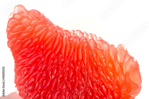 Fresh juicy grapefruit pulp background. Piece of red grapefruit macro close up. Citrus fruit texture wallpaper