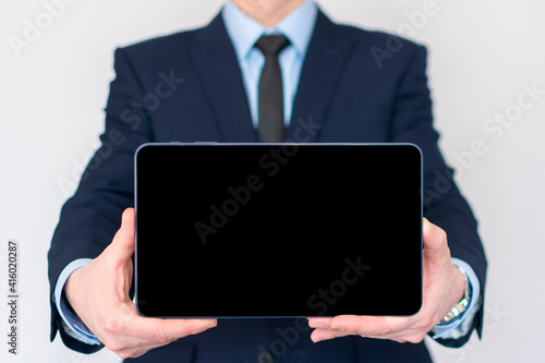 Businessman in a suit holding a tablet computer with isolated screen. Presentation mock-up