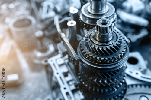 Closeup disassembled car automatic transmission gear part on workbench at garage or repair factory station for fix service or maintenance. Vehicle part detail. Complex industrial mechanism background