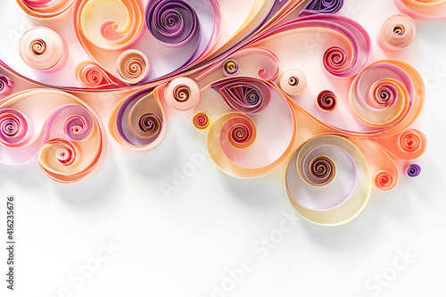 Filigree paper background. Quilling paper flower patterns from strips of twisted colored paper for art panels. Abstract floral background on white with copy space.