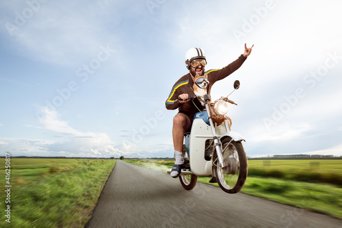 Funny biker doing a wheelie with his moped