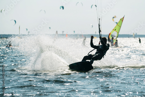 People swim in the sea on a kiteboard or kitesurfing. Summer sport learning how to kitesurf. Kite surfing on Puck bay in Jastarnia, Poland