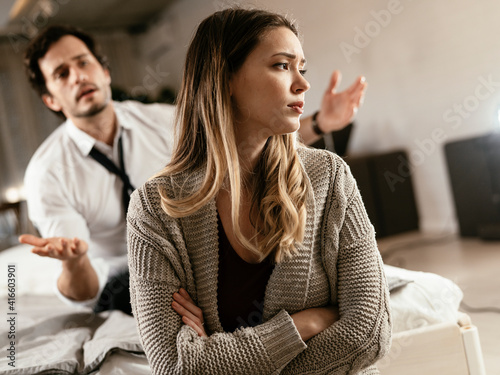 Boyfriend and girlfriend are arguing at home. Angry man is yelling at his sad girlfriend.