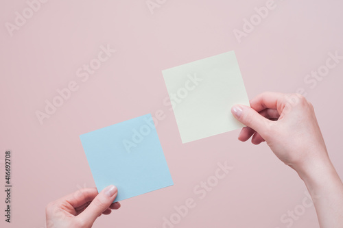 Hands holding blank sticky notes