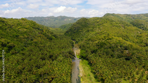 Mountain landscape with rainforest, aerial view. Hills covered with jungle. Summer and travel vacation concept. A river in the mountains on Leyte Island, Philippines.
