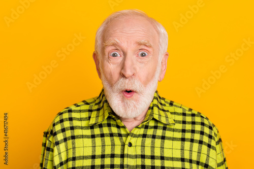 Photo of elderly man amazed shocked surprised fake novelty news rumor isolated over yellow color background