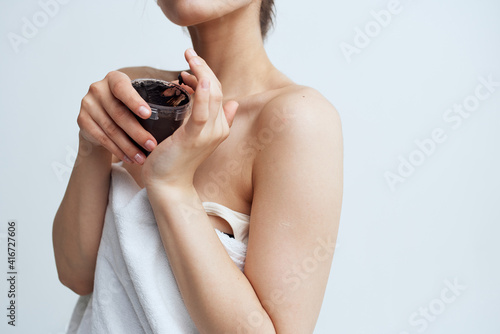 Pretty woman in white towel naked shoulders black cream in hands skin care spa procedure