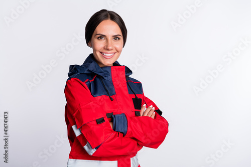 Photo of positive charming young lady paramedic dressed red uniform smiling hands folded isolated white color background