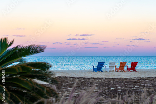 Beautiful colourful sunset and chairs on the beach of the turquoise Mediterranean sea at El Alamein near Alexandria, Egypt