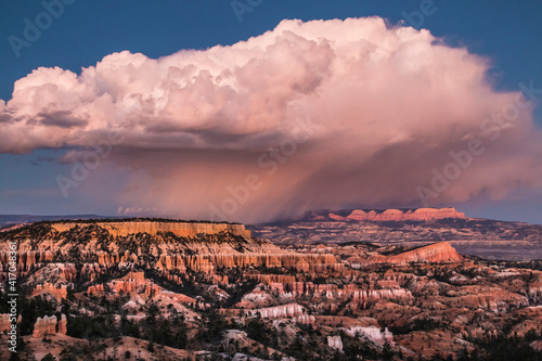 dramatic landscape photo of Bryce Canyon.gigantic cumulonimbus desert storm cloud passing through the hoodoos of the Bryce Canyon National Park just right after sunset.